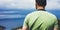 Hipster young guy with enjoying view on seascape on mountain. Tourist traveler man on background sky and blue wave landscape