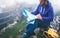 Hipster young man with backpack holding in hands and looking on map spain of foggy mountain, tourist traveler hiker