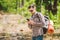 Hipster young man with backpack using smart phone on beautiful nature.Travel concept. Outdoor travel. Travel and explore