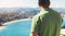 Hipster young man looking on observation deck in trip holiday in San Sebastian, enjoying view on seascape on mountain and ocean, t