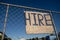 `Hire` sign on  fence with blue sky