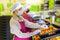 Hired farm worker in protective mask checks and sorts peaches in warehouse