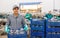 Hired food warehouse worker stacks crates of red fresh cabbage