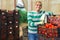 Hired latino worker carries boxes of tomatoes in the backyard