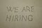 We are hiring, concept on the beach. concept text written on sand