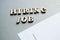 Hiring JOB is written in wooden letters on a gray background, near white sheets of paper, layout for design, ad layout, hiring