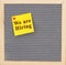 We are hiring message on sticky note on gray felt letter board