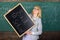 Hiring teachers for new school year. Woman teacher holds blackboard inscription back to school. Looking committed