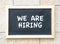 We are hiring, words printed on blackboard