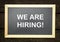 We are hiring, words printed on board