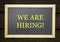 We are hiring, words printed on board