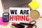 We Are Hiring Writing text in the office with surroundings such as laptop, marker, pen, stationery. Business concept for Recruitme