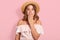 Hirizontal shot of young woman wearing summer blouse, sunglasses and straw hat, keeps hand on open mouth, being in shock, looks