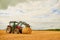 His farm is well-kept. Shot of a farmer stacking hale bales with a tractor on his farm.