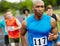 His goal is in sight. Front view of a male runner looking determined while running in a race with other athletes in the