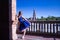 Hispanic adult female classical ballet dancer in blue tutu doing figures on the terrace of a plaza next to a beautiful tiled
