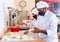 Hispanic baker kneading and forming dough for baking bread