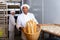 Hispanic baker showing fresh baked baguettes in bakery