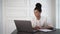 Hispanic businesswoman consultant with laptop talking in white room