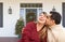 Hispanic and Caucasian Young Adult Couple On Christmas Decorated Front Porch of House