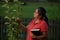 Hispanic Christian Woman Contemplating her Pear Tree After Working Her Yard and Having Meditation