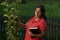 Hispanic Christian Woman Touching Pear Tree and Holding Bible