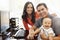 Hispanic couple and baby in home office