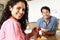 Hispanic couple eating cereal and fruit in kitchen