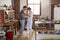 Hispanic couple in pyjamas dancing in kitchen, full length