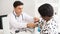 Hispanic doctor measuring African American patient\\\'s blood pressure. Person medical healthcare and wellbeing, the physician