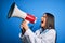 Hispanic doctor woman wearing medical white coat shouting angry on protest through megaphone