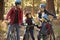 Hispanic family on bikes in a forest looking at each other