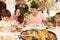 Hispanic Family Enjoying Outdoor Meal At Home Together