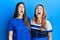 Hispanic family of mother and daughter wearing casual clothes over blue background angry and mad screaming frustrated and furious,