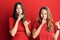Hispanic family of mother and daughter wearing casual clothes over red background asking to be quiet with finger on lips pointing