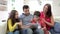 Hispanic Family Sitting On Sofa With Digital Tablet