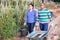 Hispanic farmer couple carrying wheelbarrow and bucket