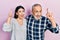 Hispanic father and daughter wearing casual clothes smiling amazed and surprised and pointing up with fingers and raised arms