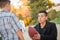 Hispanic Father Holding Football Teaching Young Boy