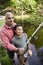 Hispanic father and son fishing in pond