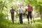 Hispanic father and sons hiking on trail in woods