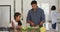 Hispanic father teaching smiling daughter cooking in kitchen