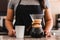 Hispanic female barista pouring coffee