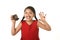 Hispanic female child in red dress eating chocolate donut with hands and mouth stained and dirty smiling happy