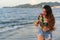 Hispanic girl walks along beach, sends text
