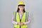 Hispanic girl wearing builder uniform and hardhat with hand on stomach because nausea, painful disease feeling unwell
