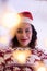 Hispanic girl wearing Santa hat and Christmas sweater at home. decoration with colorful lights