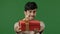 Hispanic happy man giving gift large red box with gold ribbon studio green background portrait friendly indian guy