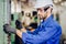 Hispanic latin labor worker hard working with safety glasses and helmet with heavy metal machine in factory industry