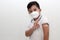 Hispanic little boy with face mask and school uniform shirt shows his recently vaccinated arm against Covid-19 in the new normal f